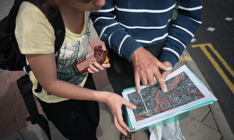 Close up of two people reading a map of Bristol, indicating areas of flood risk in red.