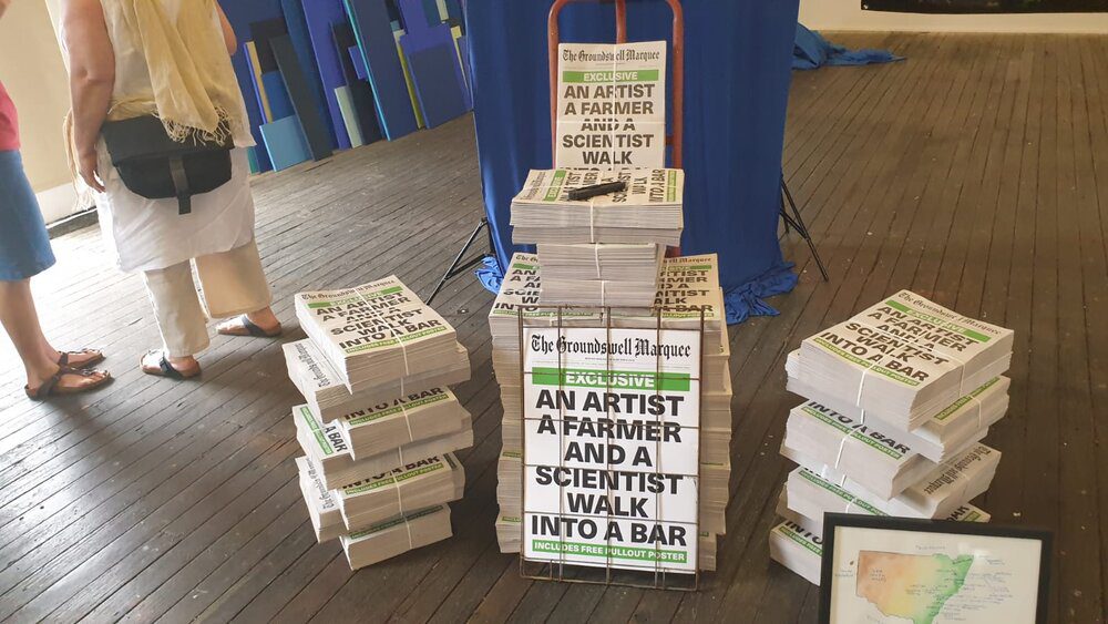 Stacks of newspapers with the headline: 'An artist, a farmer and a scientist walk into a bar'