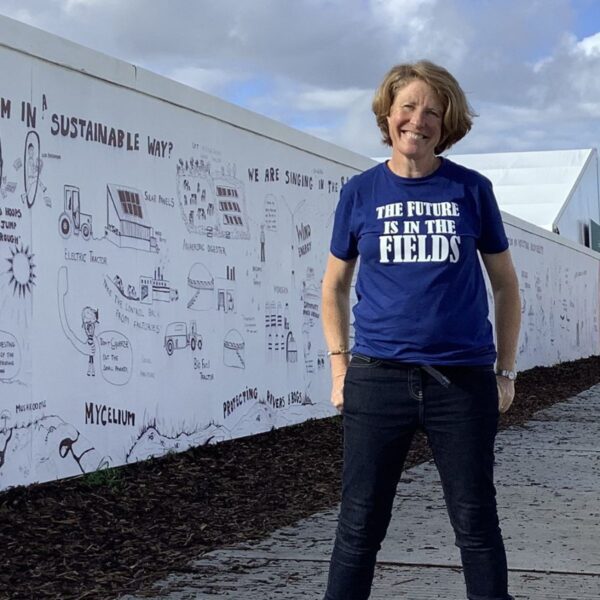 Artist Lisa Fingleton standing in front of the Creative Climate Wall