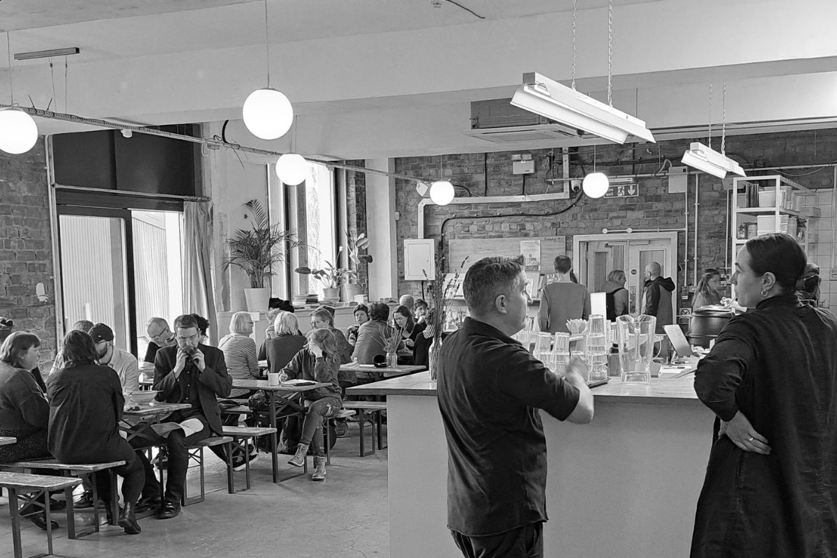 Black and white photo of people sitting and standing having conversations