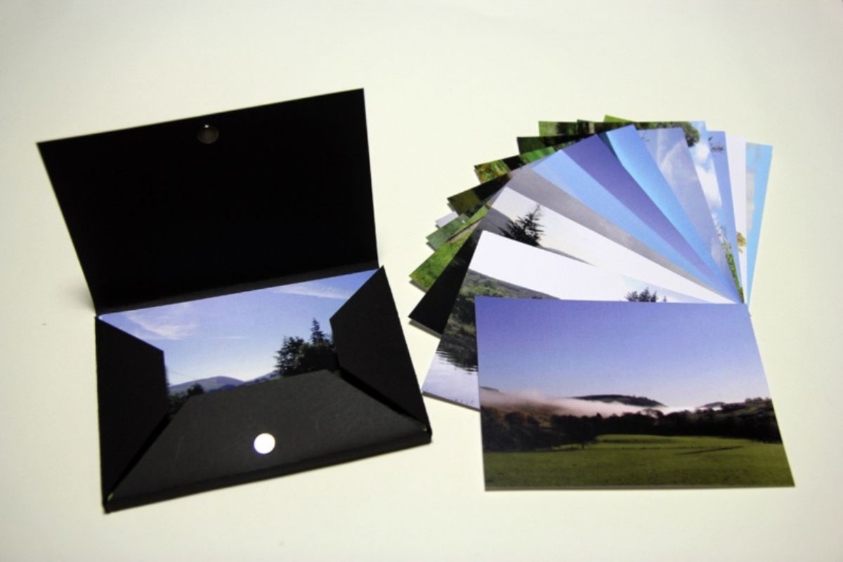 A selection of printed photos next to a black envelope