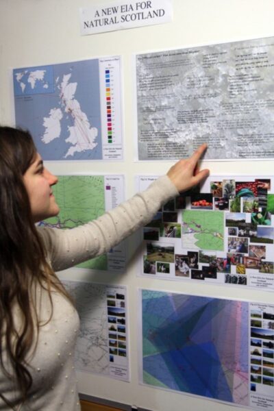 A person pointing at a poster on the wall