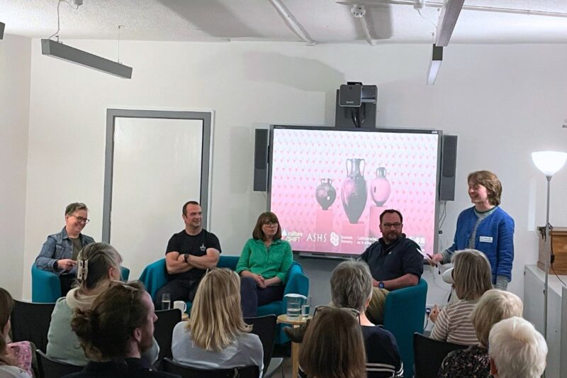 Panel discussion with five people and an audience watching