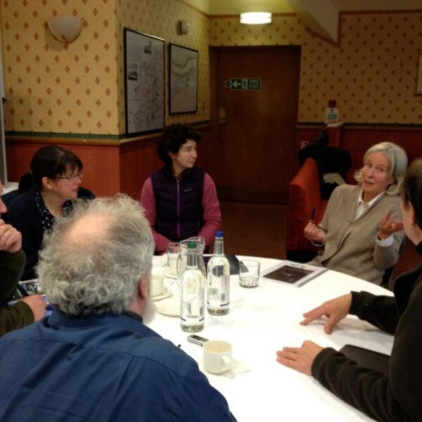 Participants in a workshop sitting and talking around a table.