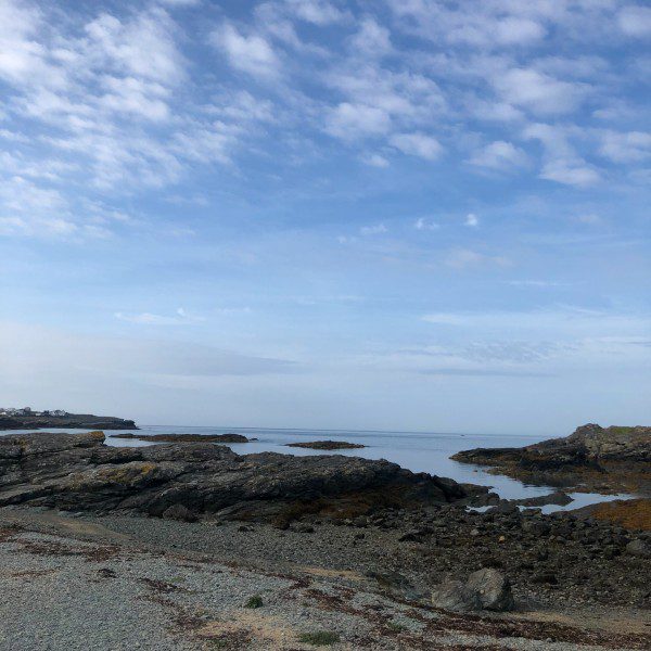 A rocky coastal landscape, with blue skies.