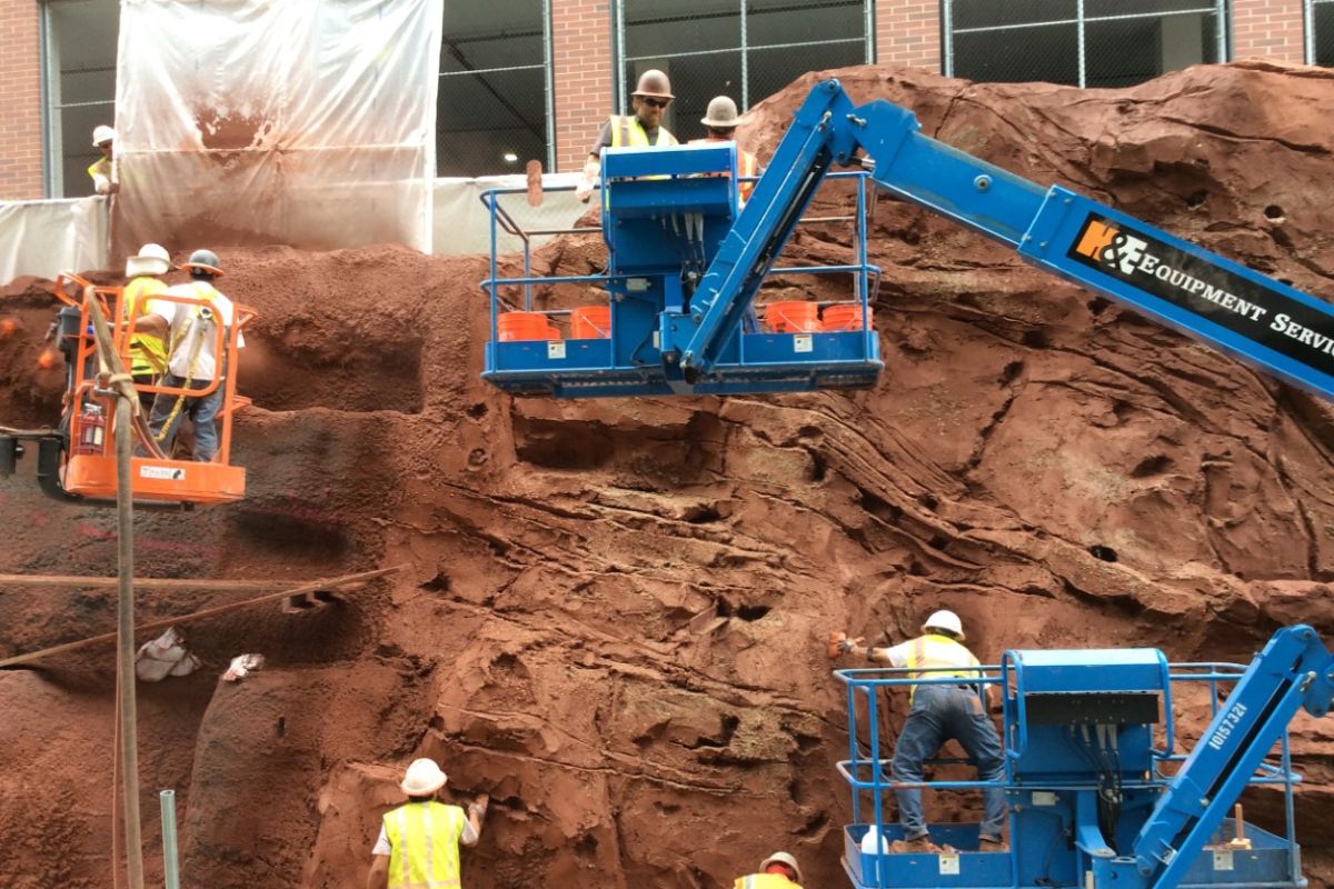 Construction workers on aerial lifts working on the public artwork The Draw