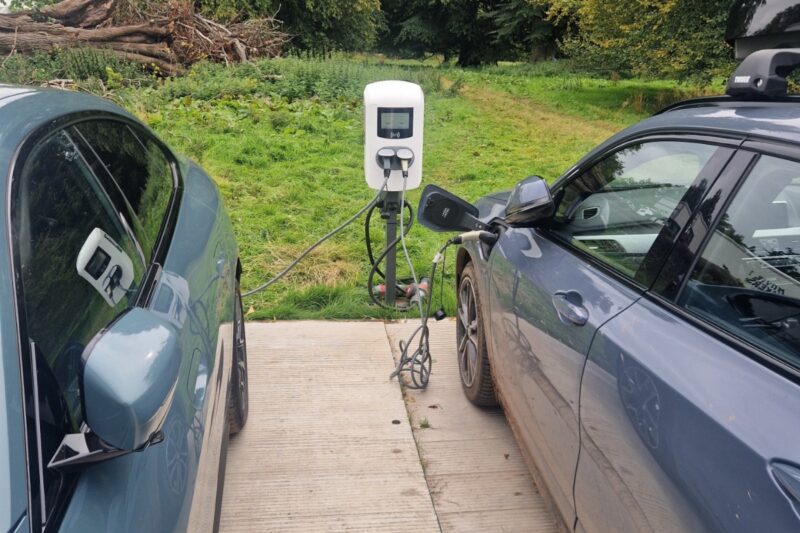 Two cars plugged into an EV charger.