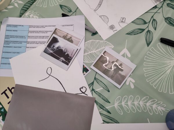 A collection of old-looking photos laid out on a green tablecloth