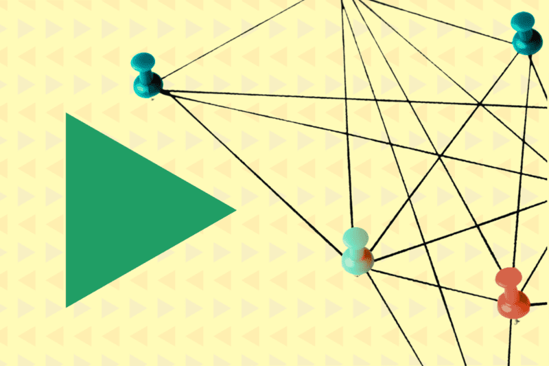 A green triangle next to four different coloured pins holding down an intricate network of string. The background is yellow.