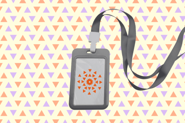 A gray lanyard with a plastic badge holder displays an abstract orange geometric design. Background is a pattern of orange and purple triangles.
