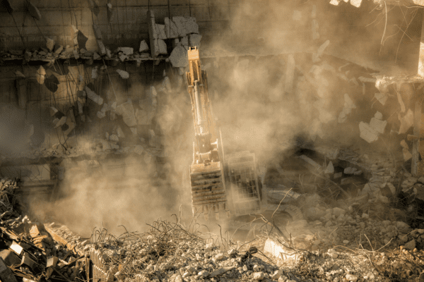 Machinery demolishing and repairing a building
